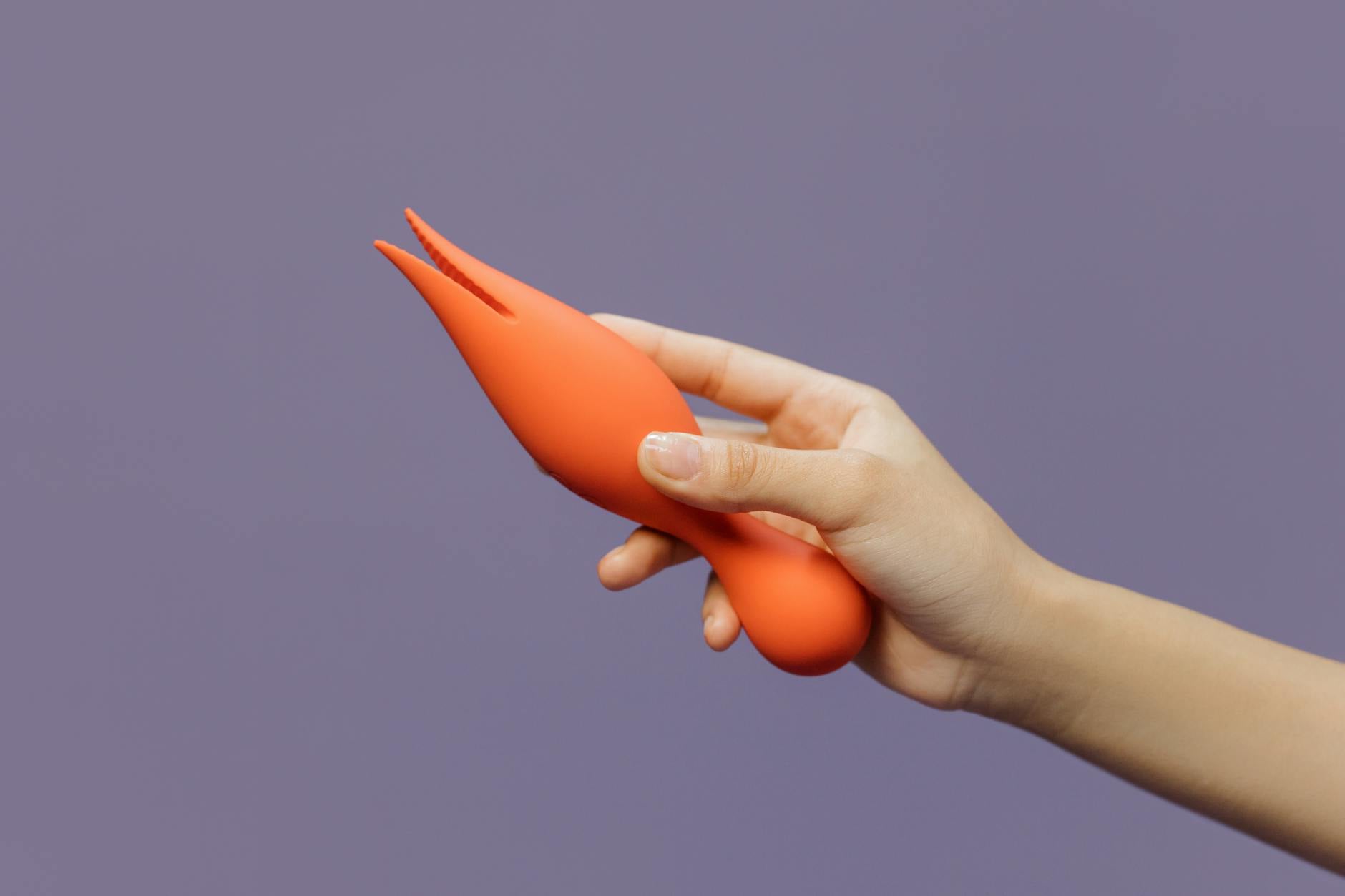 Hand holding a lemon vibrator against a minimalist backdrop, representing pleasure and self-discovery